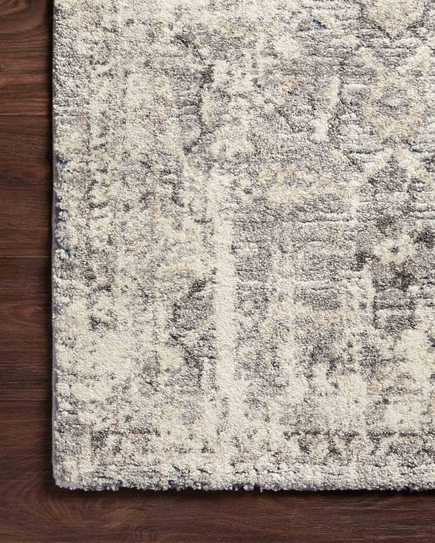 Natural and grey power-loomed rug edge with distressed geometric motifs on floor