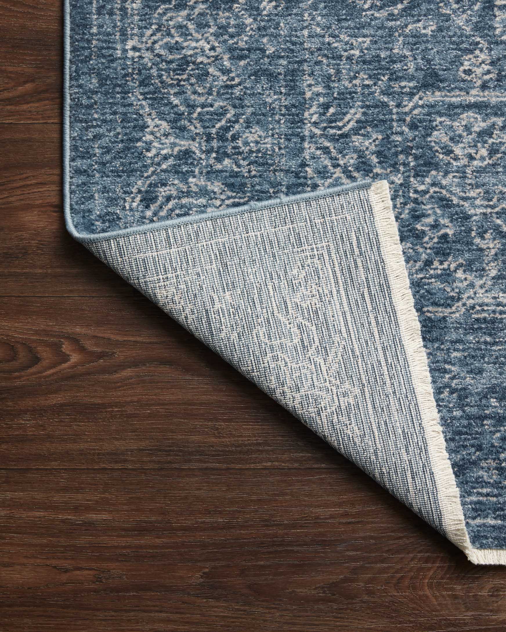 Denim blue rug underside with light woven border and heathered texture