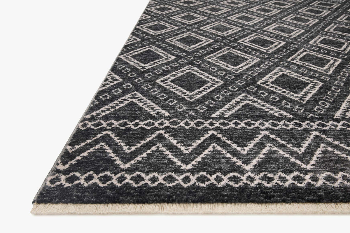 Charcoal rug corner with dove diamond pattern and short fringe edge