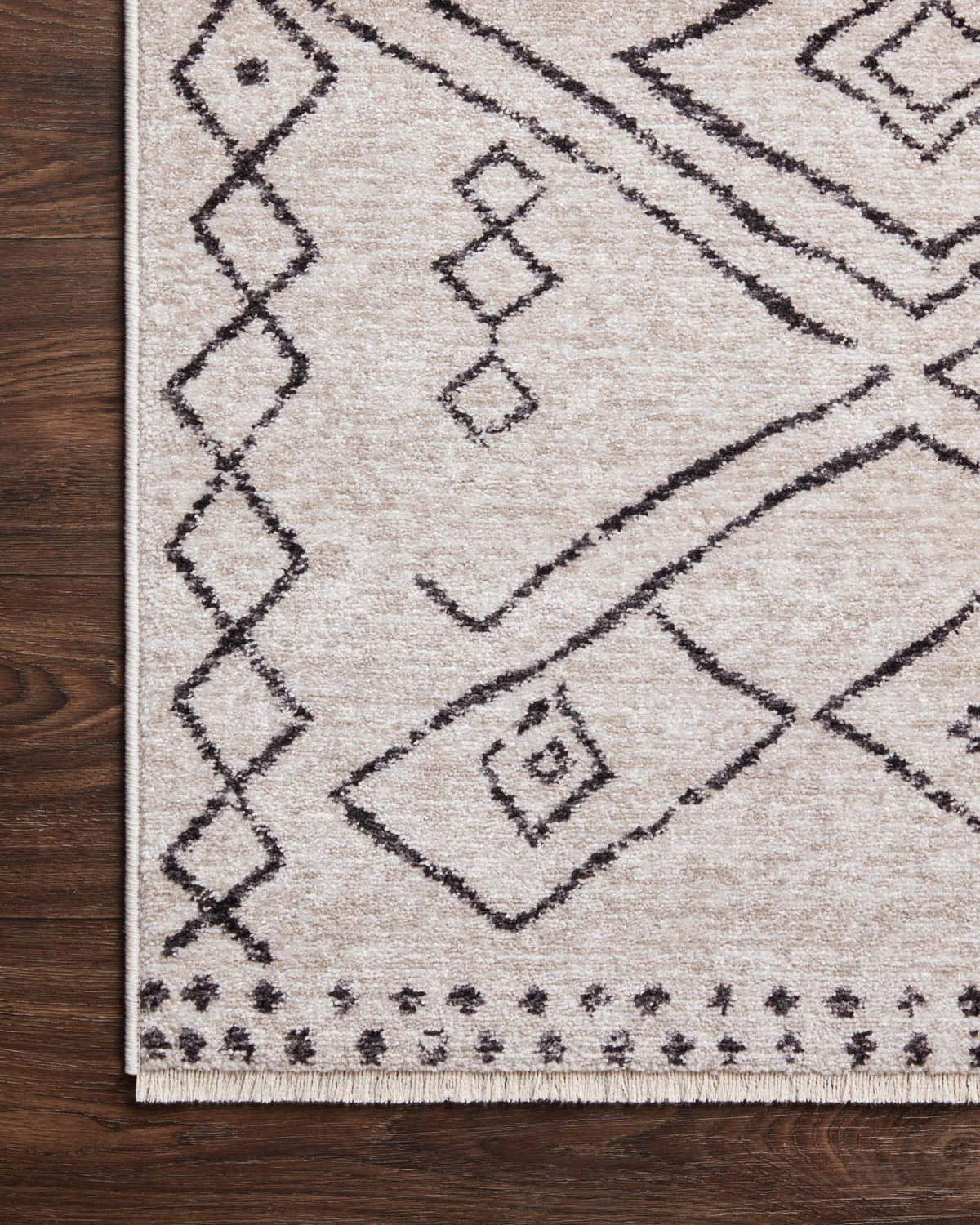 Dove rug with charcoal diamond lines and small geometric squares, corner