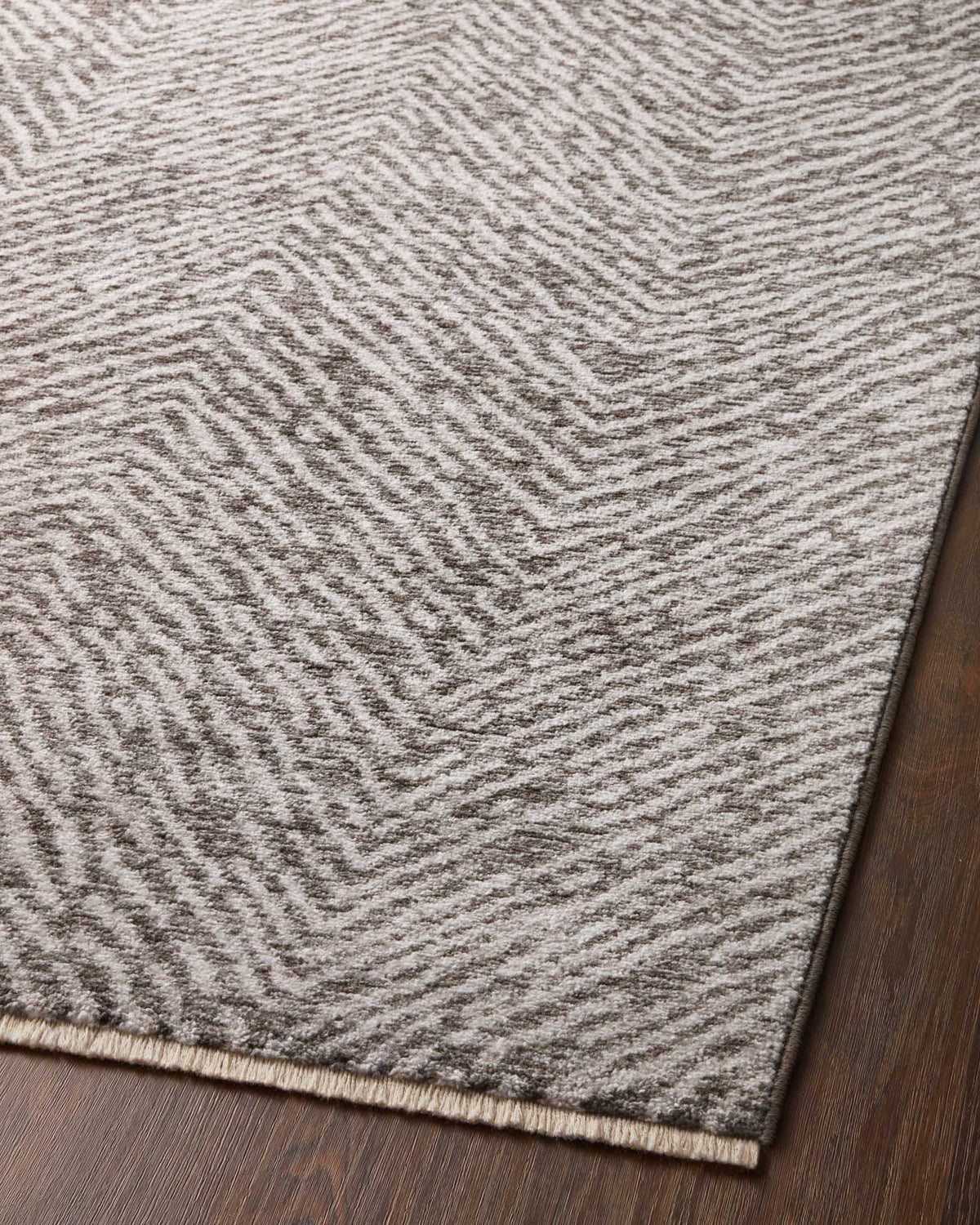 Close-up of taupe and dove chevron power-loomed rug pattern with bound edge