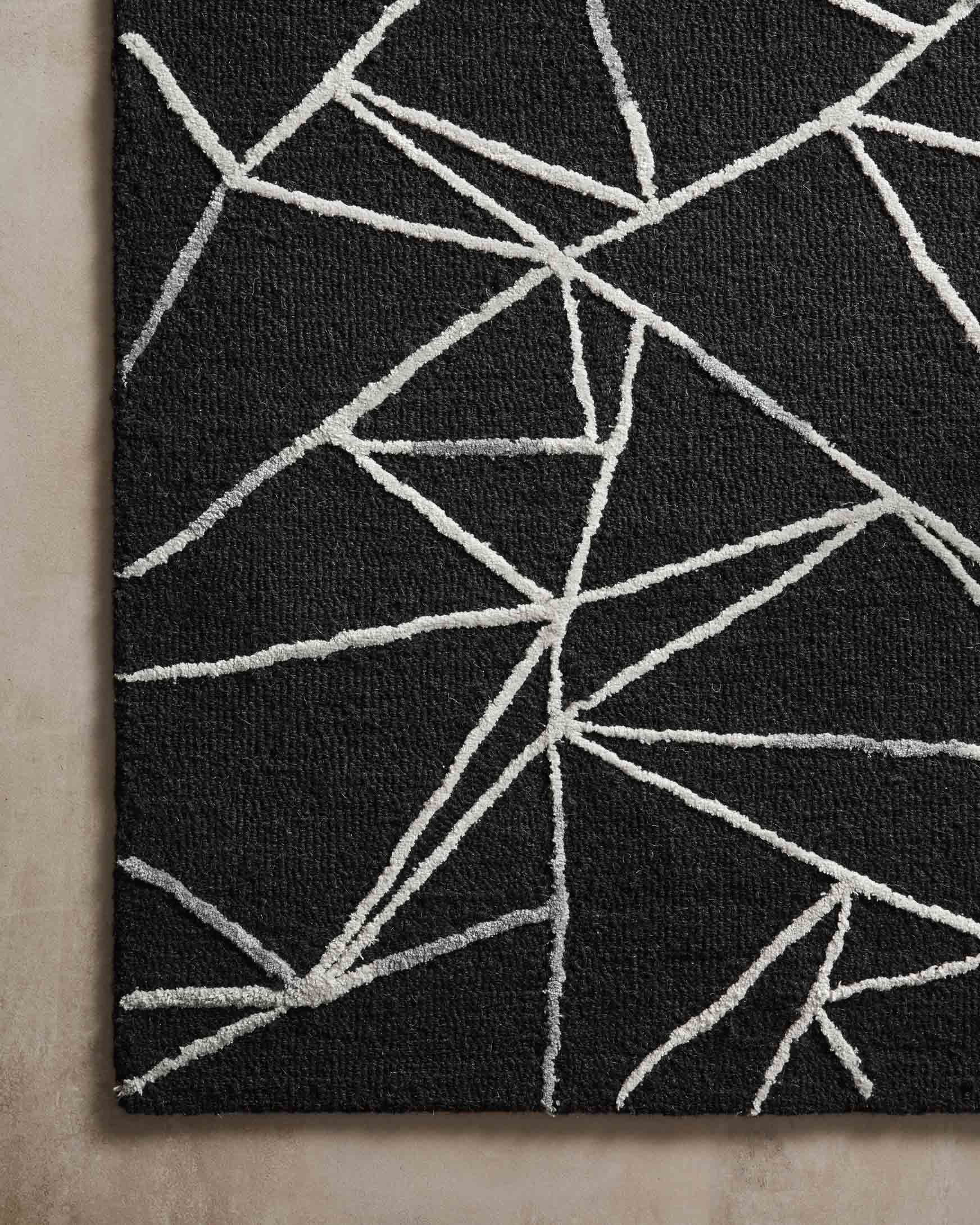 Close-up of black hand-tufted rug with ivory geometric lines and textured surface