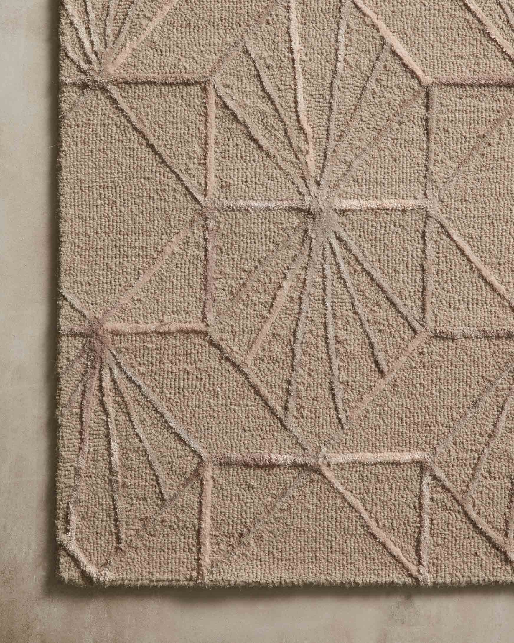 Close-up of sand and blush hand-tufted rug showing textured tufted geometric fans
