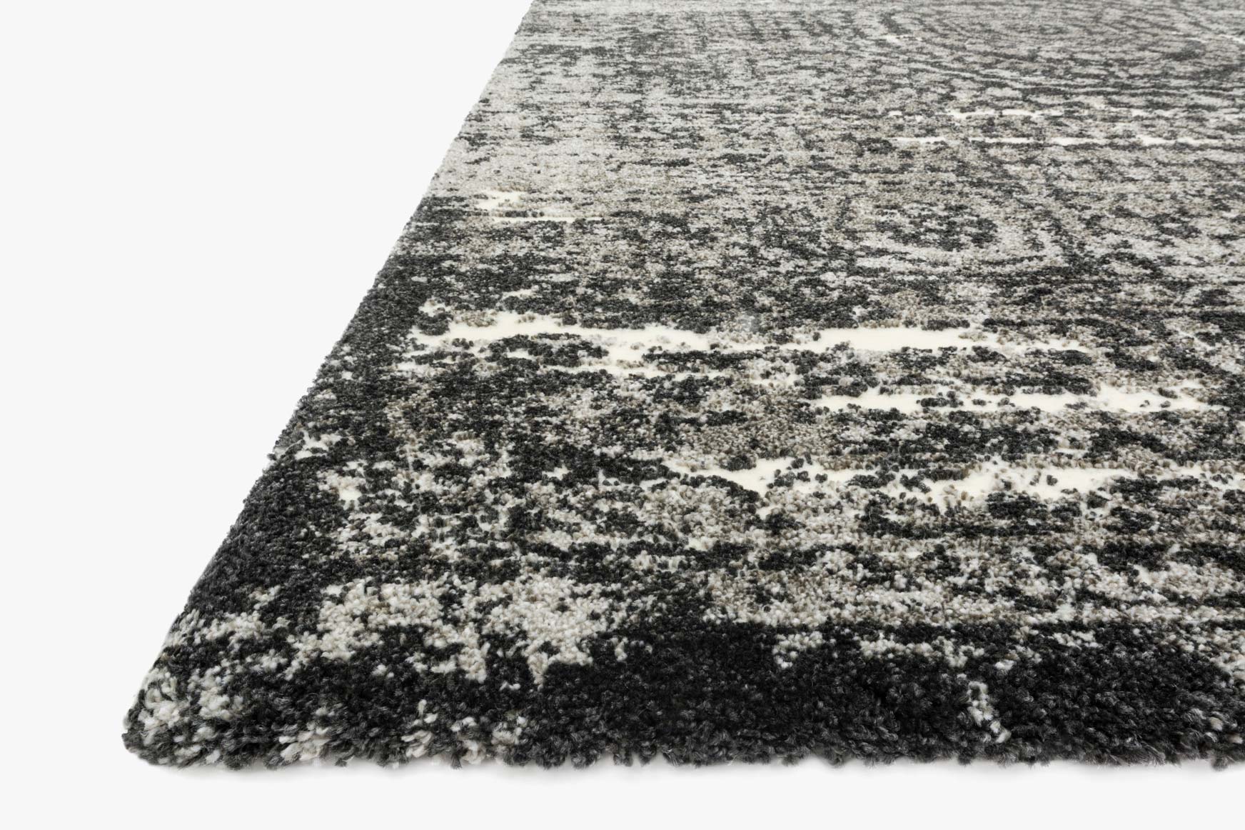 Corner view of distressed abstract rug with short pile, graphite and black
