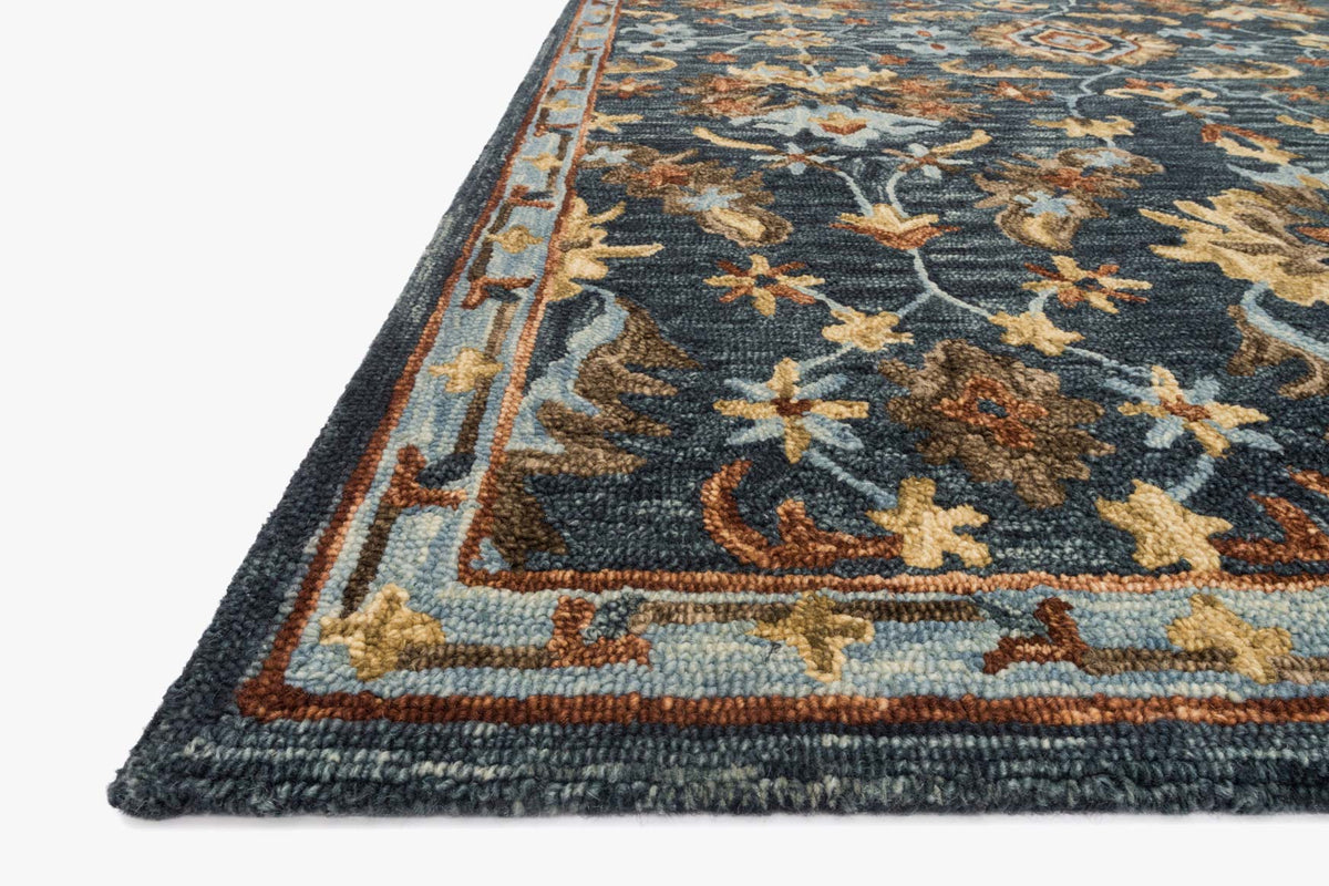 Hooked rug corner detail with navy ground, gold and rust floral motifs and border