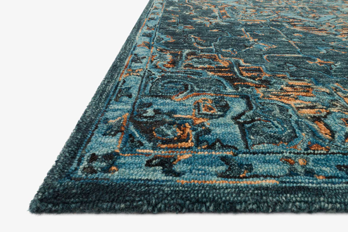 Teal hooked rug corner close-up with multicolor pattern and short fringe