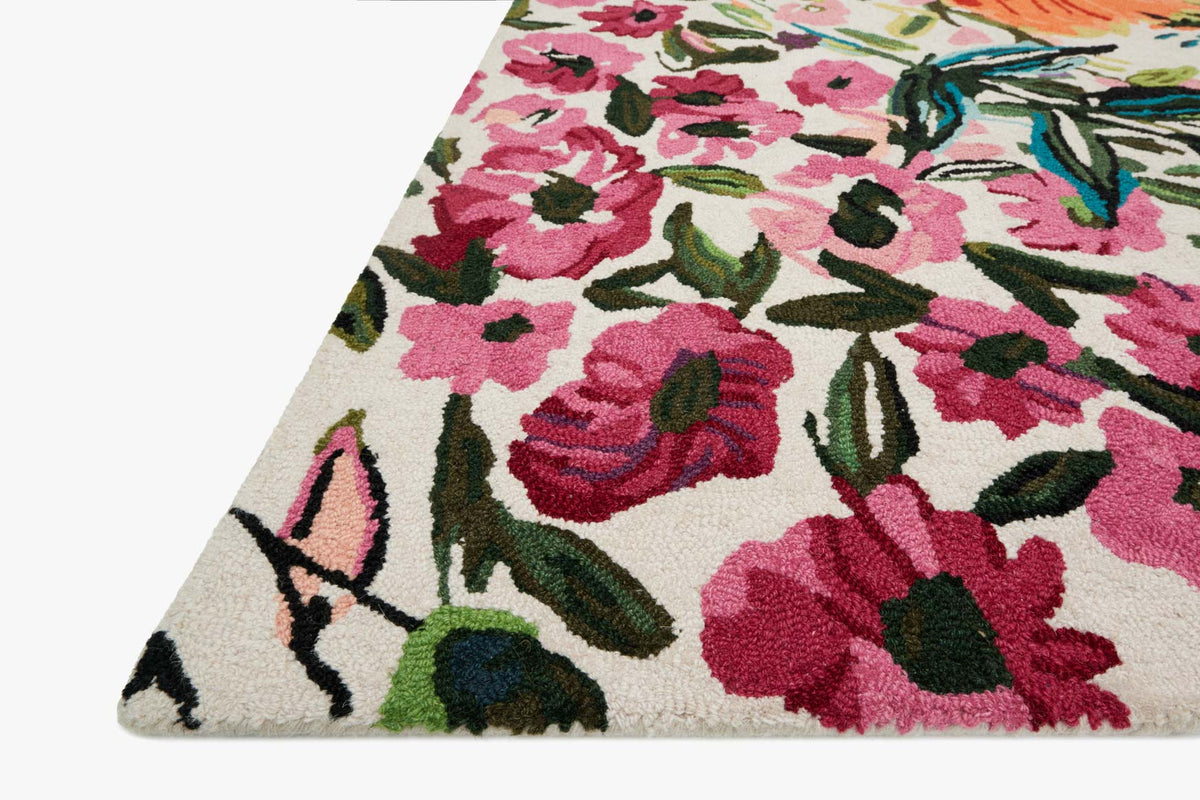 Corner view of ivory floral hooked rug with pink/red blossoms and green leaves
