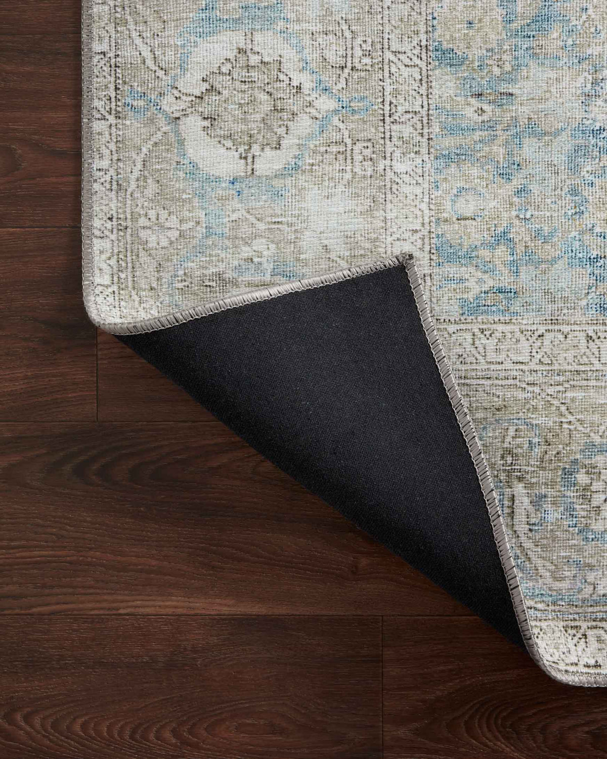Corner underside view with dark backing fabric and light blue woven top