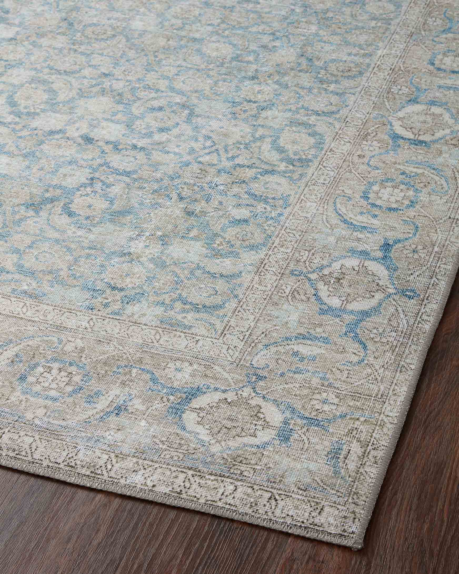 Top view of light blue traditional rug with silver vine-like corner medallions