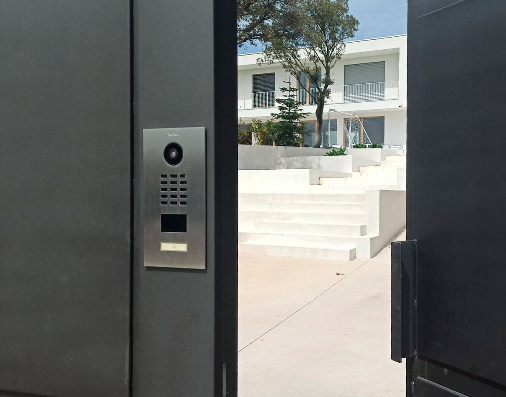 Stainless steel video door intercom mounted near gate entrance with camera panel