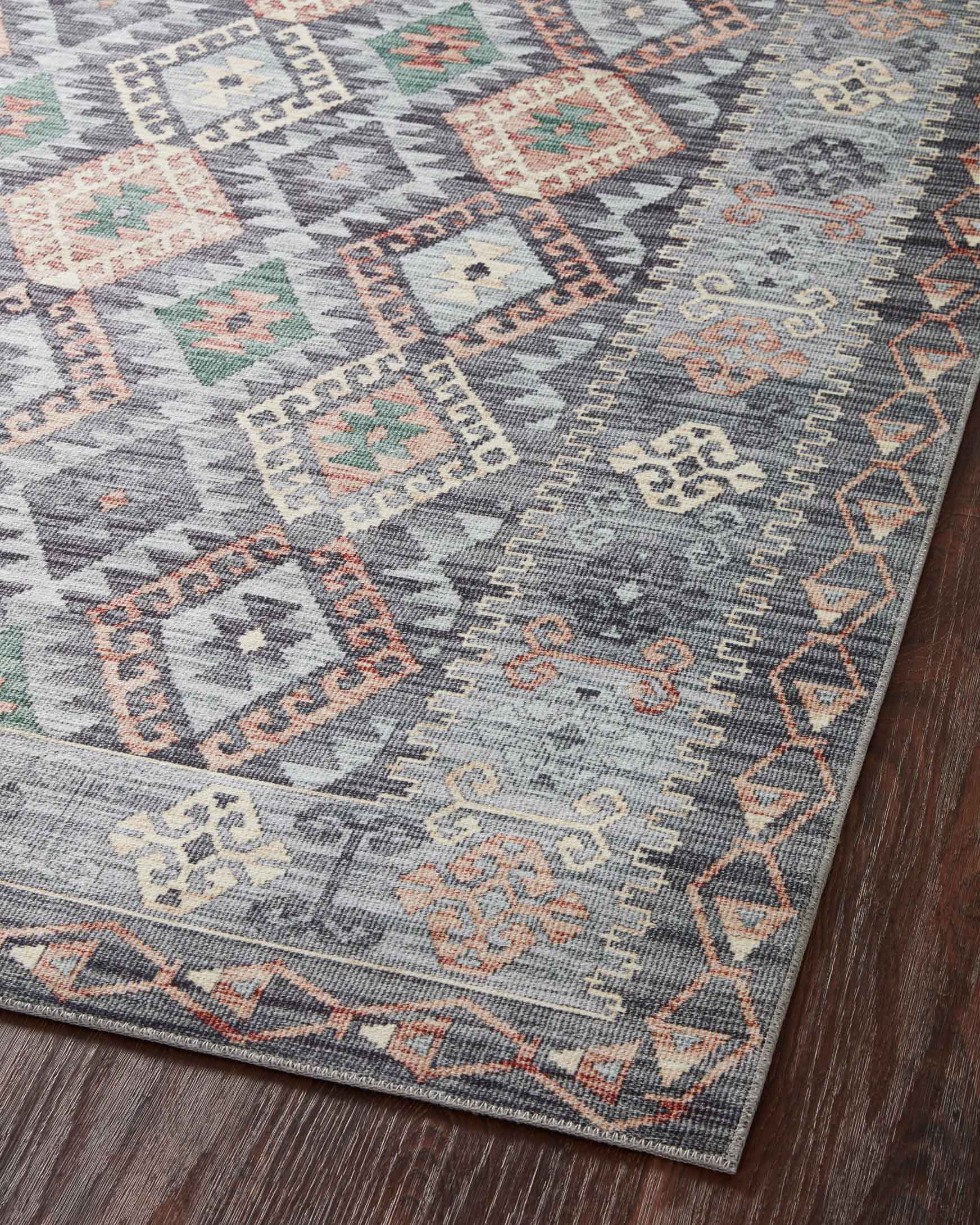 Overhead view of grey geometric rug with multicolor diamond pattern on wood floor