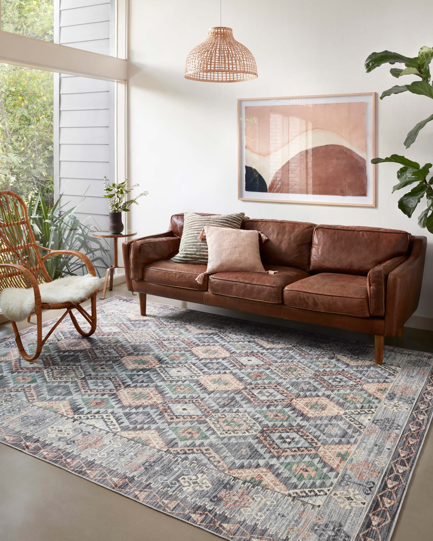 Grey geometric area rug with multicolor diamond pattern, shown in a living room