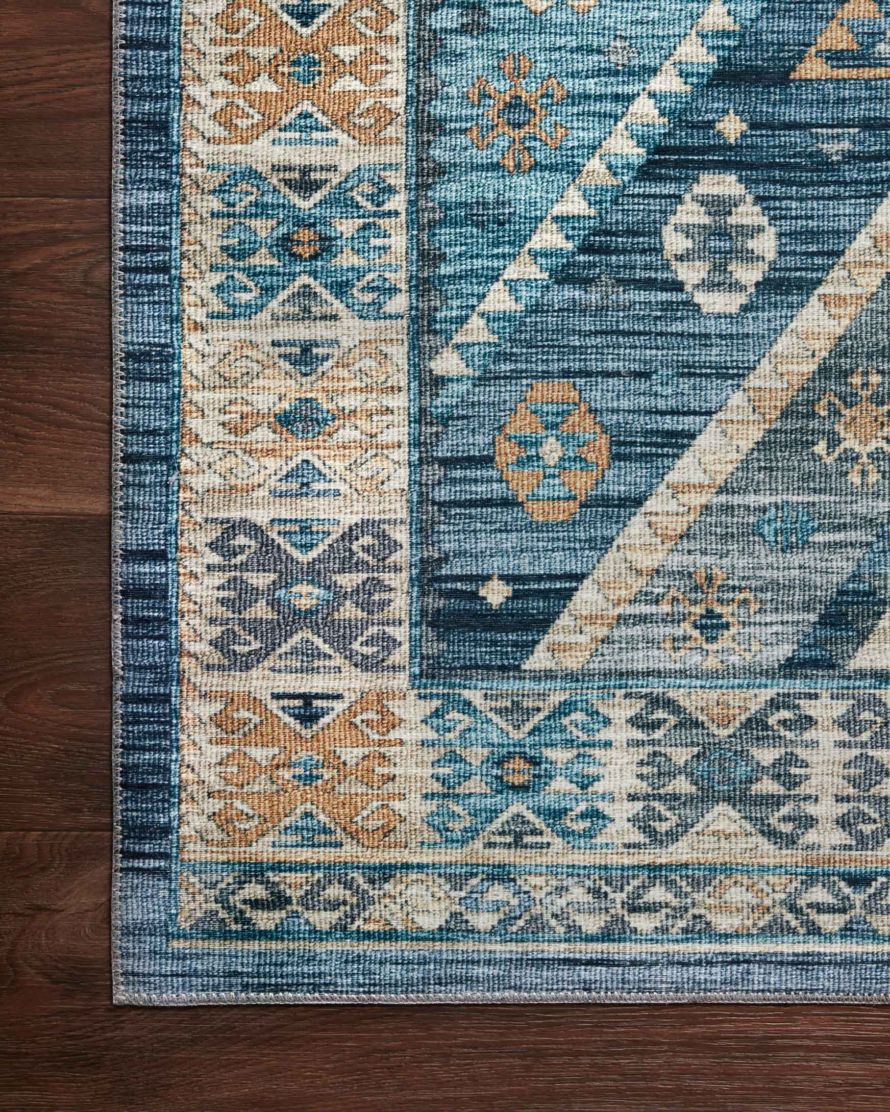 Corner detail showing blue rug field with gold and cream geometric blocks and border