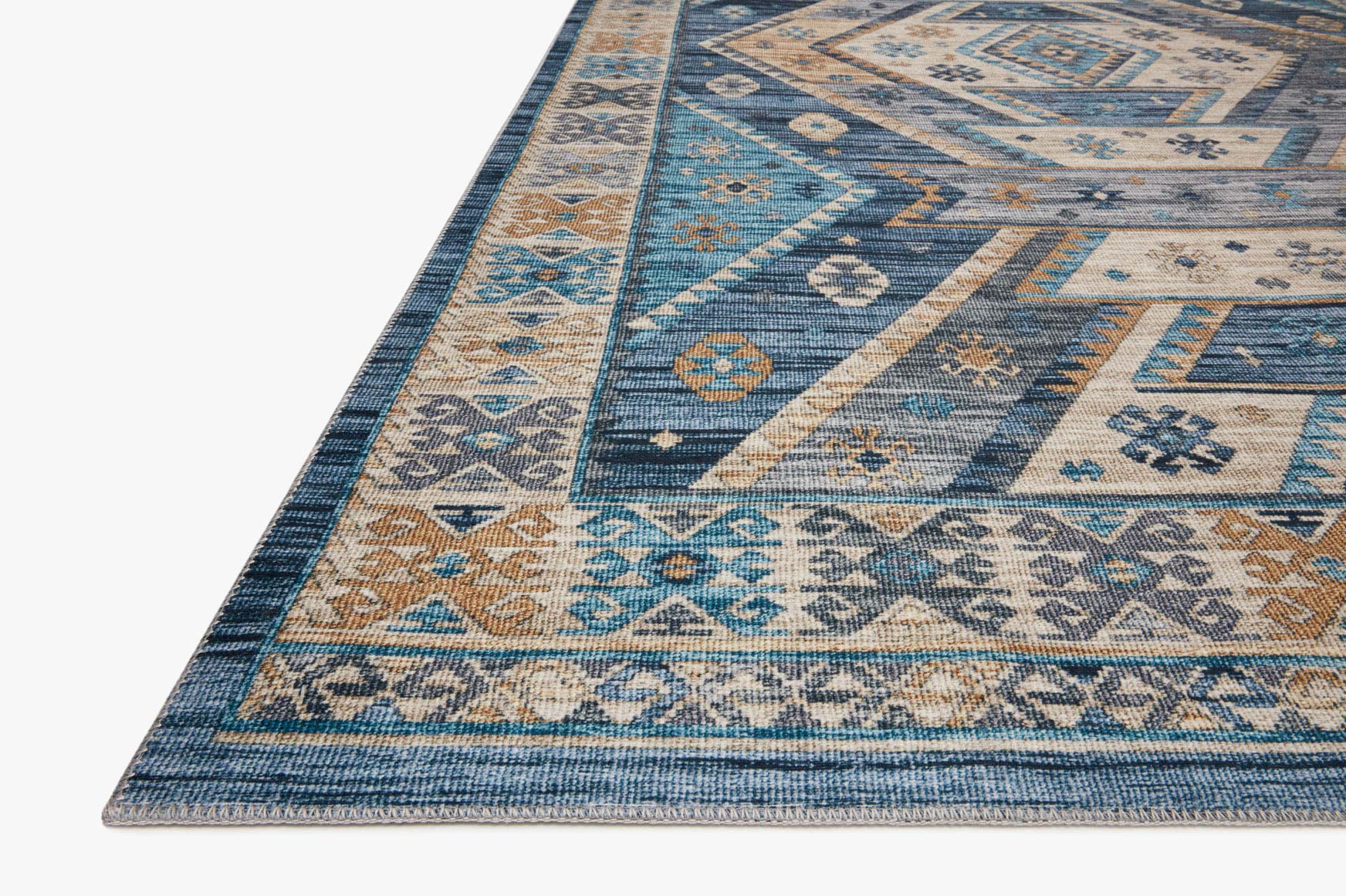 Close-up of blue, gold, and cream rug border with woven geometric motifs