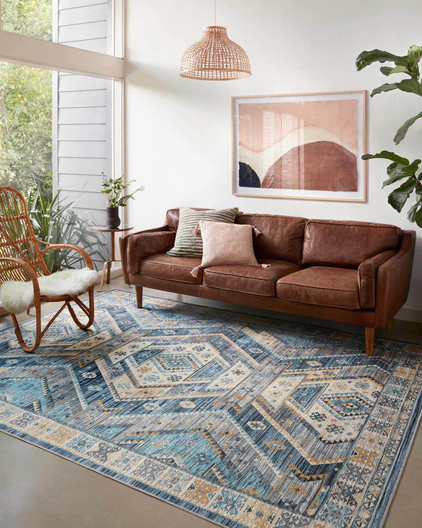 Blue and gold geometric area rug laid on hardwood flooring beneath a sofa