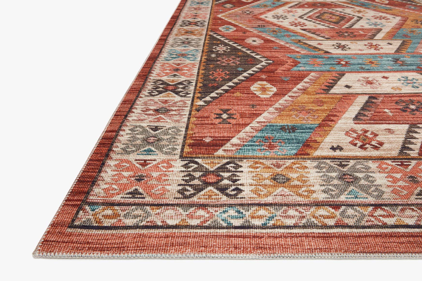 Close-up of multicolor geometric traditional rug edge with red and teal accents