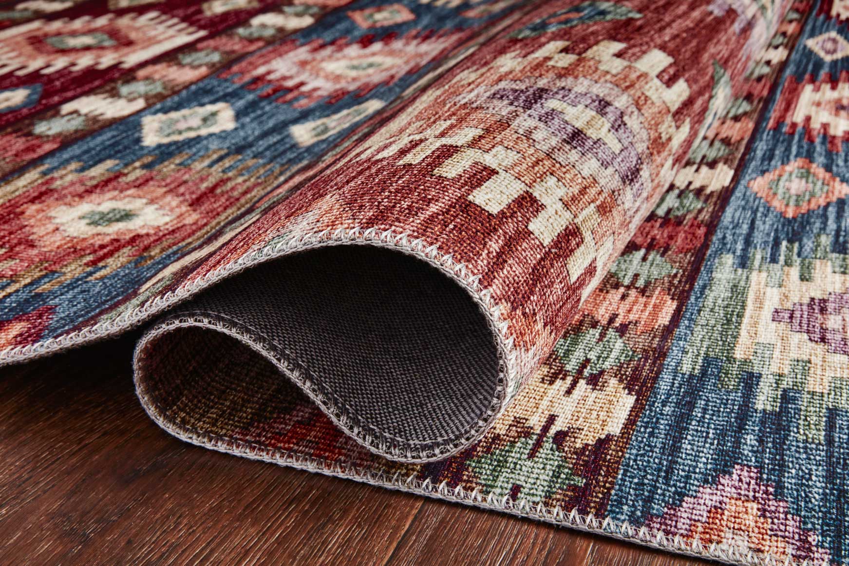 Multicolor rug corner with bound edge and short-pile weave, geometric pattern