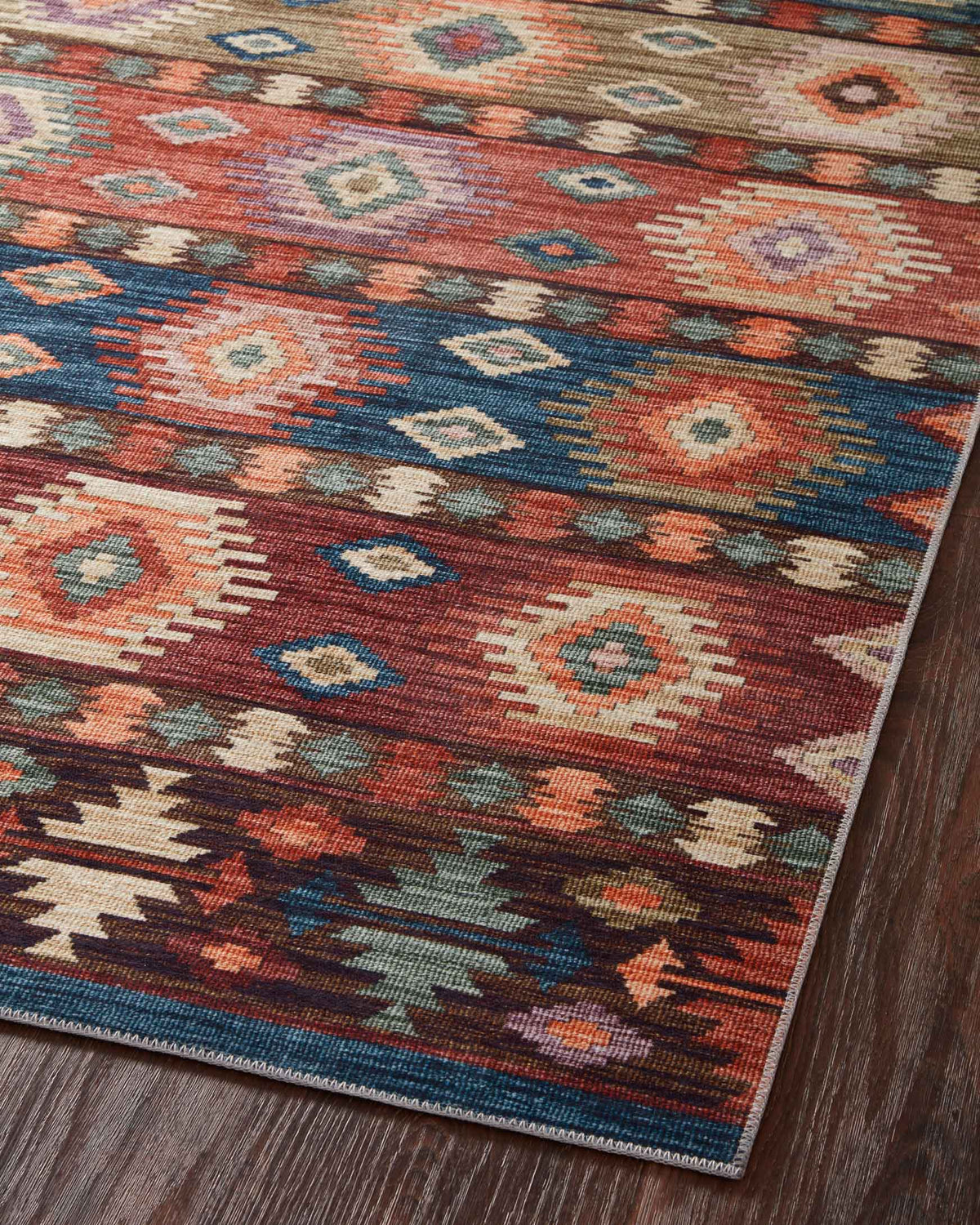 Close-up of multicolor geometric rug with small diamond pattern and blue border