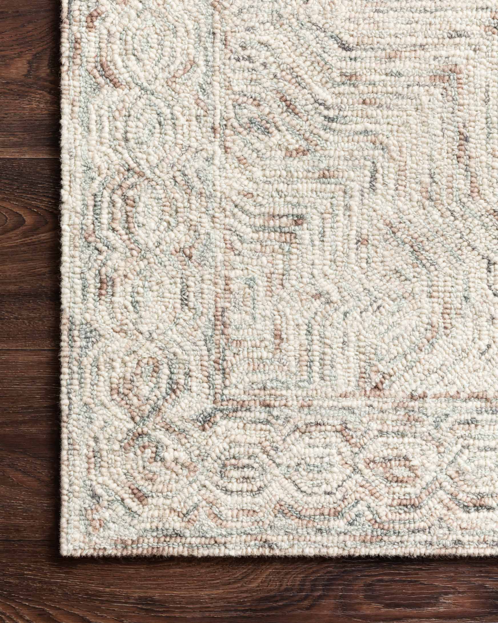 Close-up of light beige rug with raised loop pile and muted geometric medallion pattern