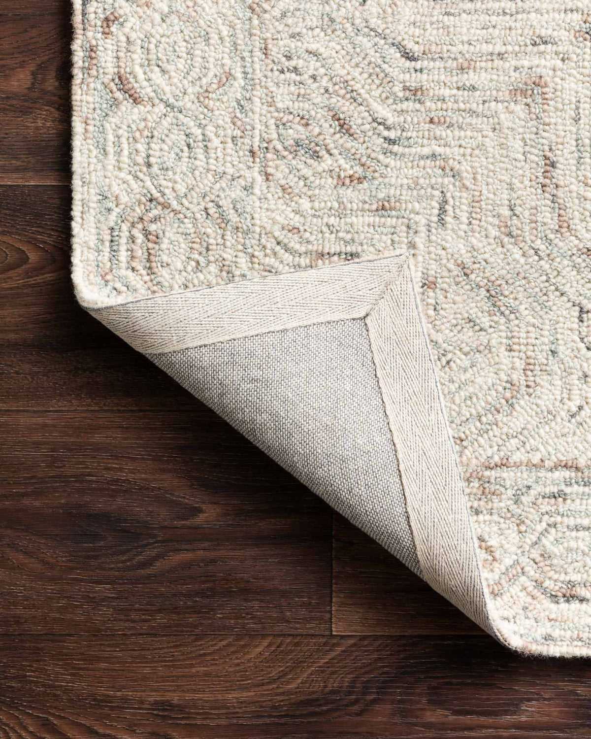 Light beige rug edge with sewn border and textured loop pile