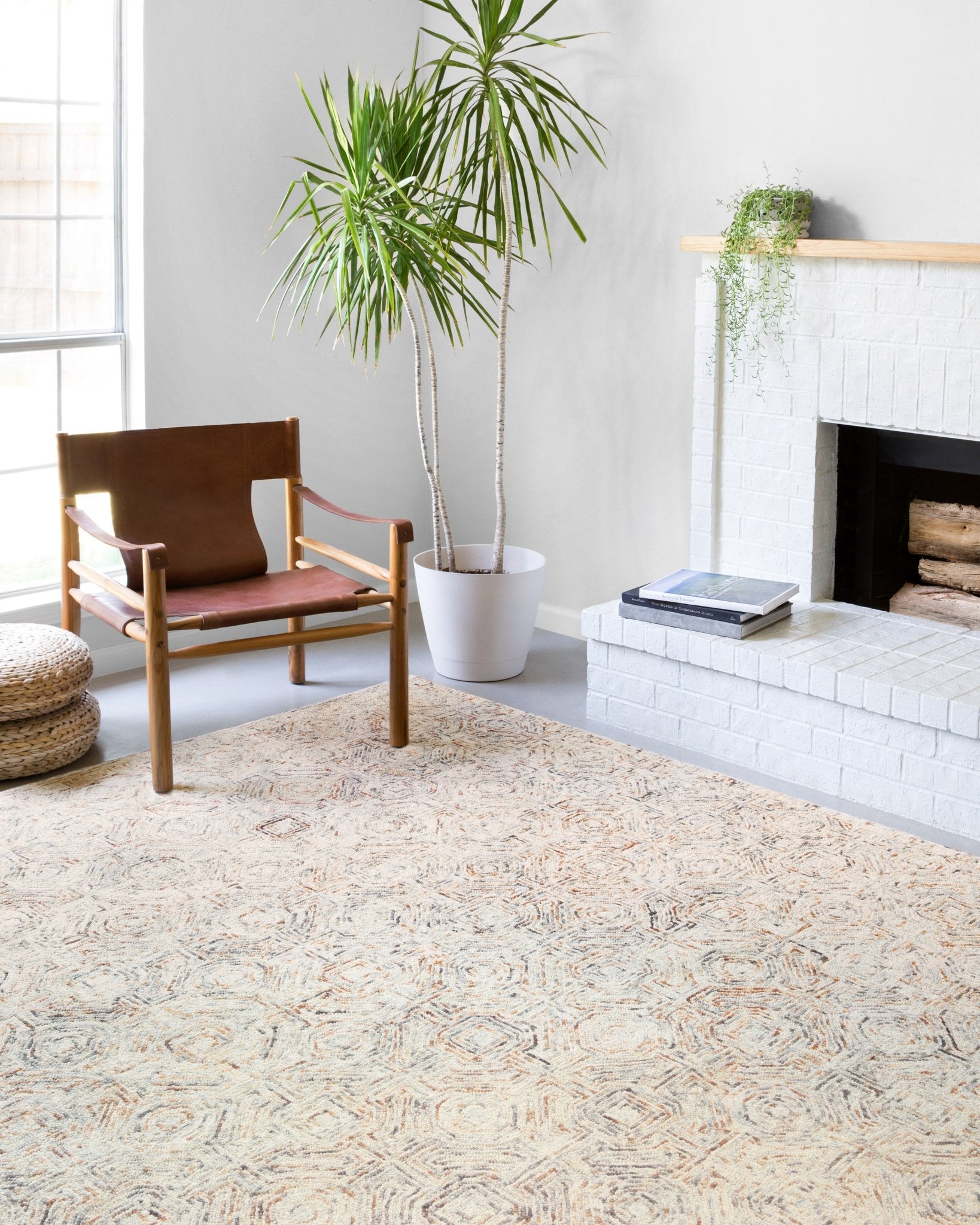 Hand-tufted area rug with cream and orange geometric pattern, shown on floor