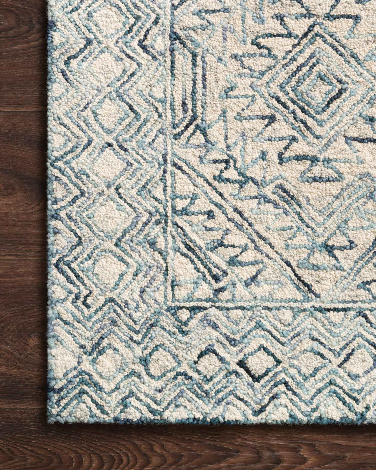 Hand-tufted rug close-up showing raised geometric lines in bluestone and ivory