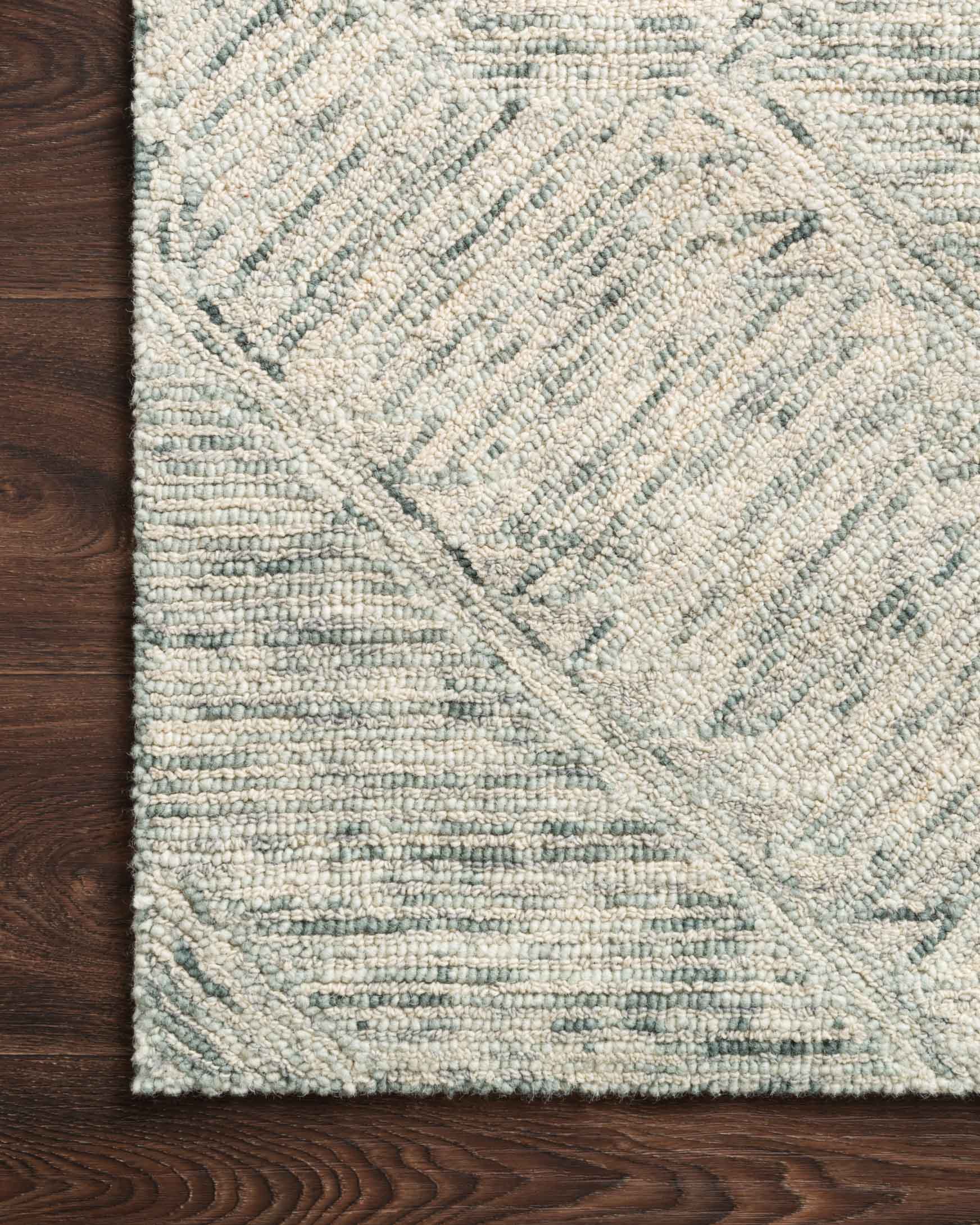Hand-tufted rug surface with sky-blue and ivory geometric diamond pattern