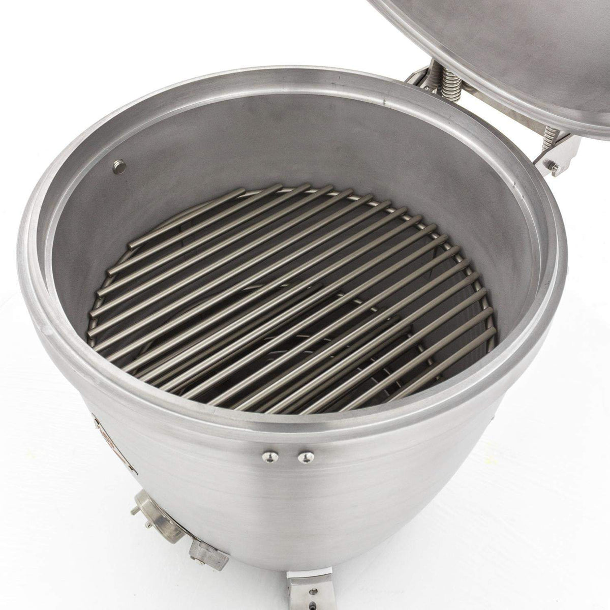 Cast aluminum kamado grill interior with metal cooking grate and dark firebox