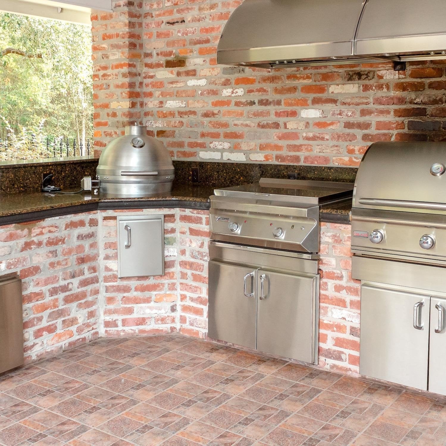 Stainless outdoor kitchen setup featuring kamado grill with open lid