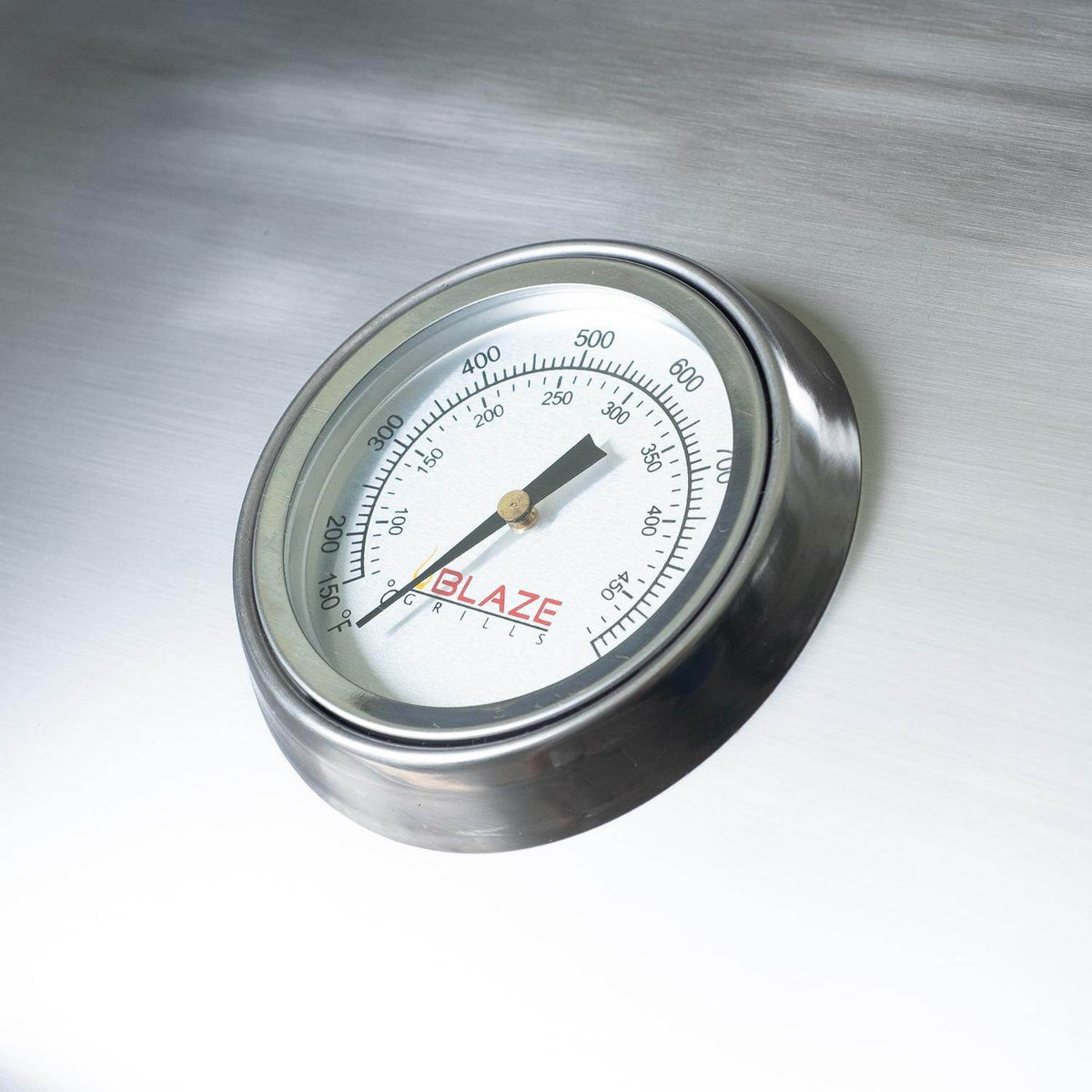 Round Blaze temperature gauge on stainless steel grill lid