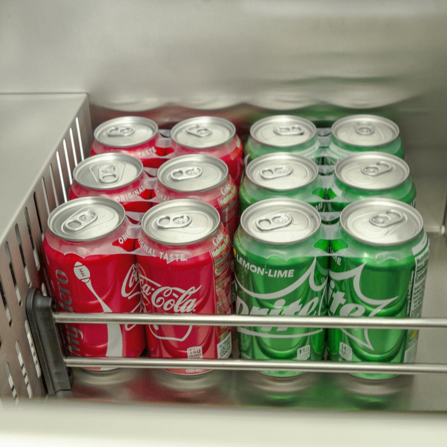 Outdoor refrigerator drawer filled with mixed soda cans in two rows