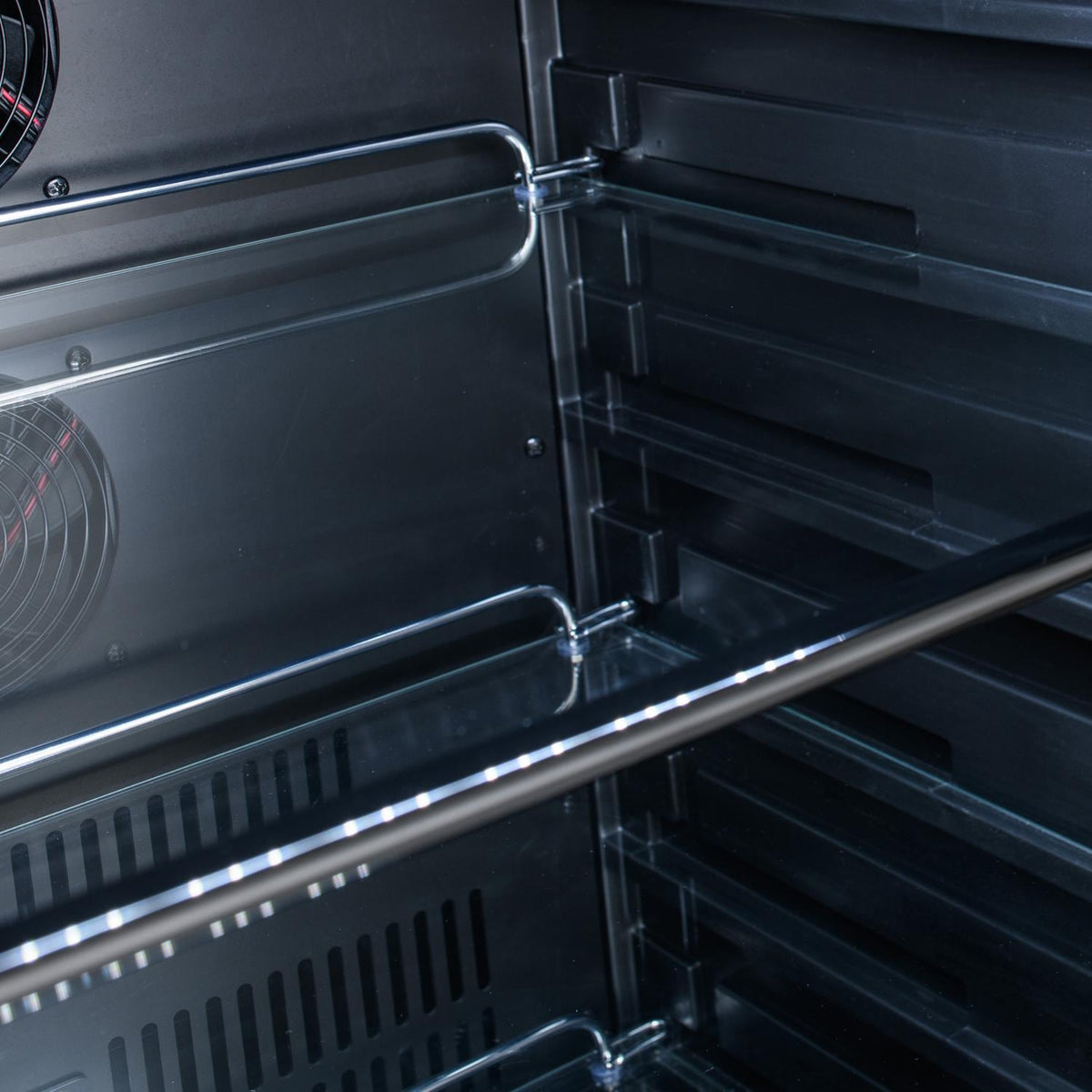 Stainless steel grill interior with heating tubes and reflective heat deflectors