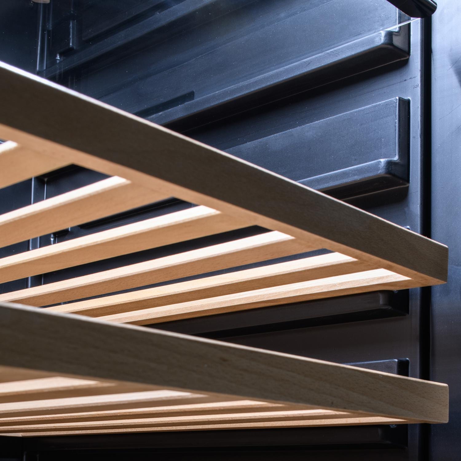 Close-up of stainless grill with slatted wooden warming rack