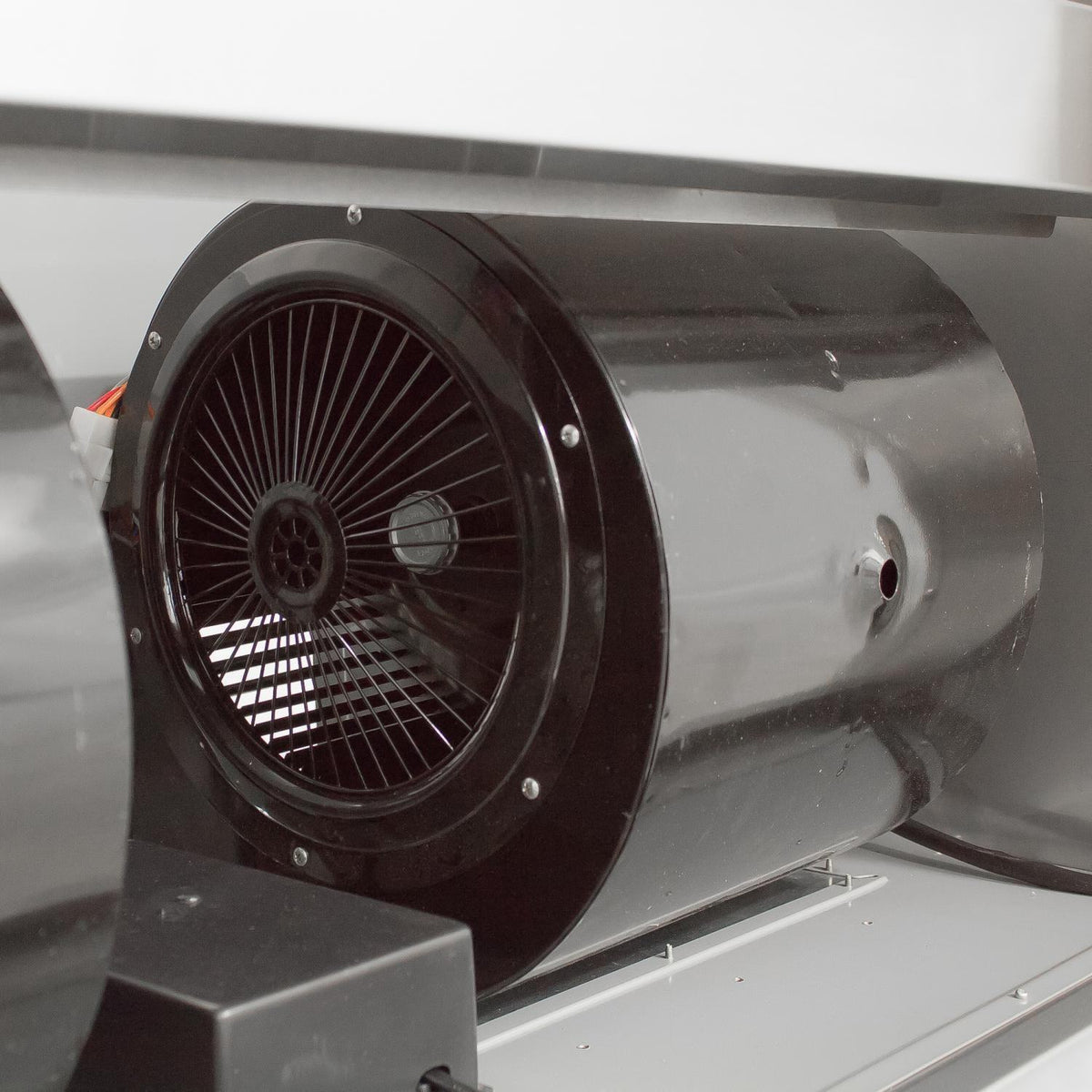 Stainless steel vent hood with circular fan intake and protective grille