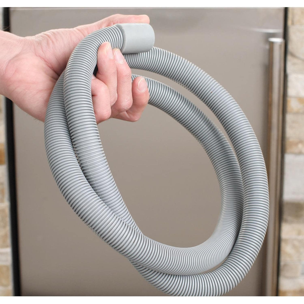 Coiled white corrugated drain hose attached to the ice maker