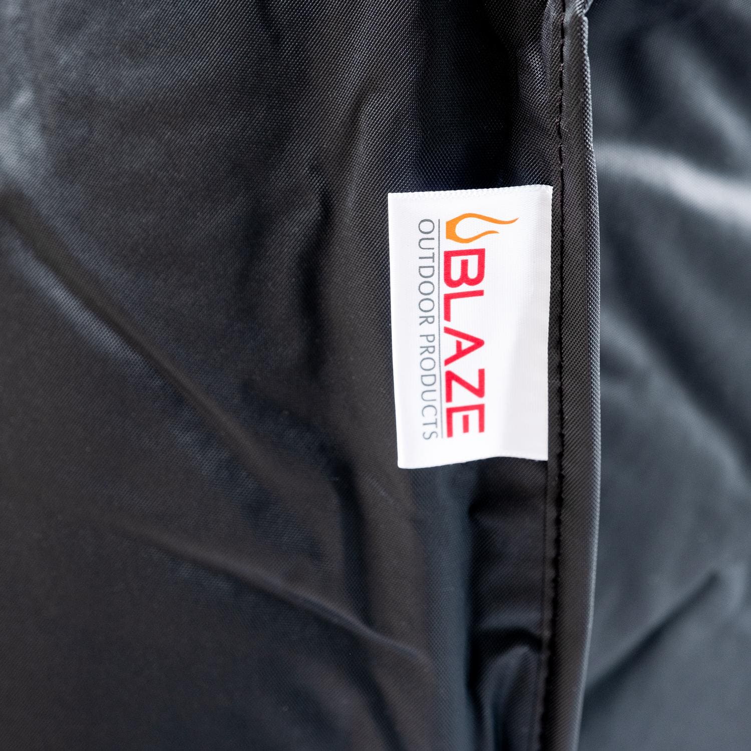 Dark gray grill cover with Blaze tag label on front panel