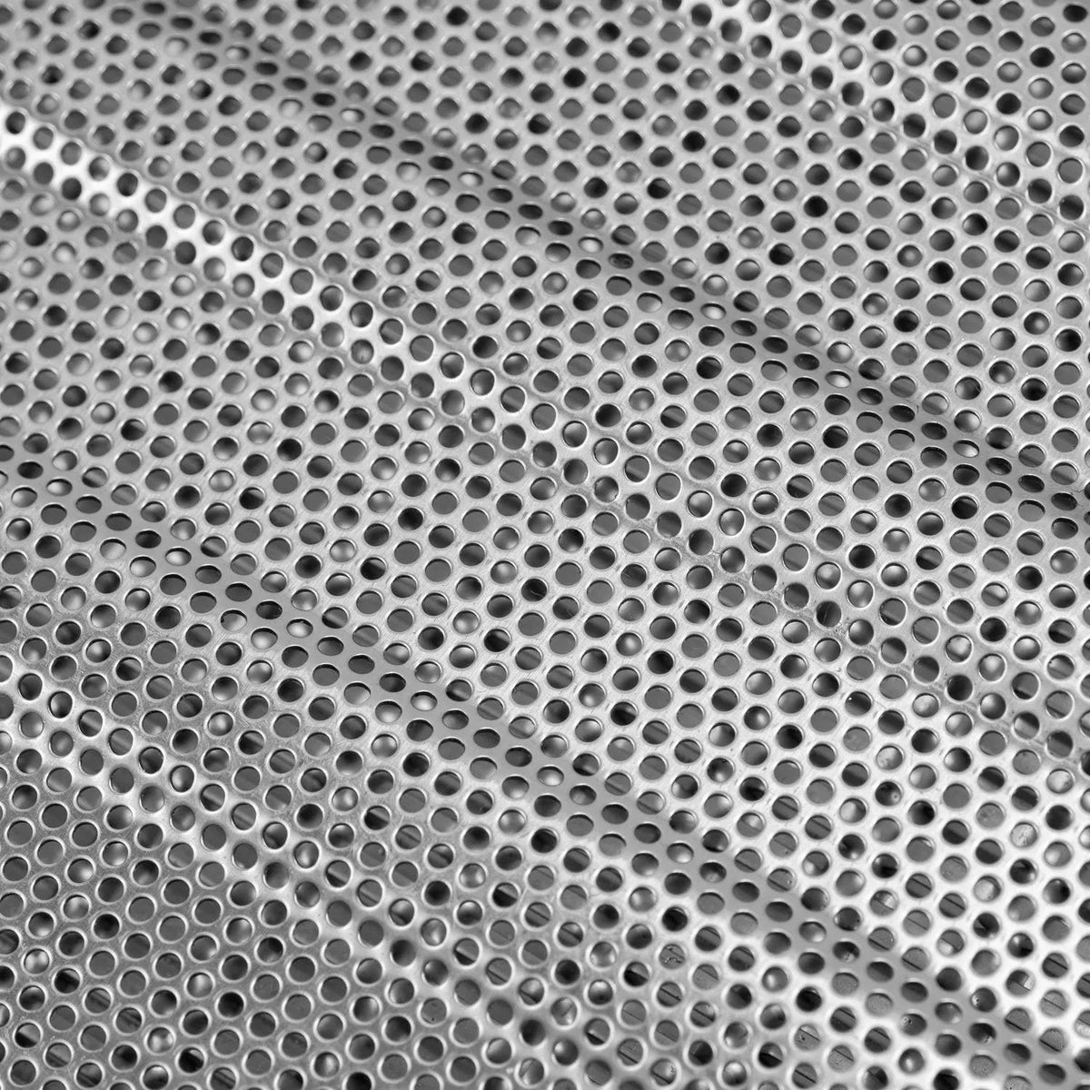 Close-up of perforated metal flame tamer sheet with round ventilation holes