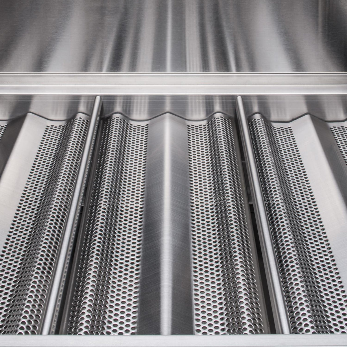 Close-up of stainless steel cooking grates with ridged burner channels