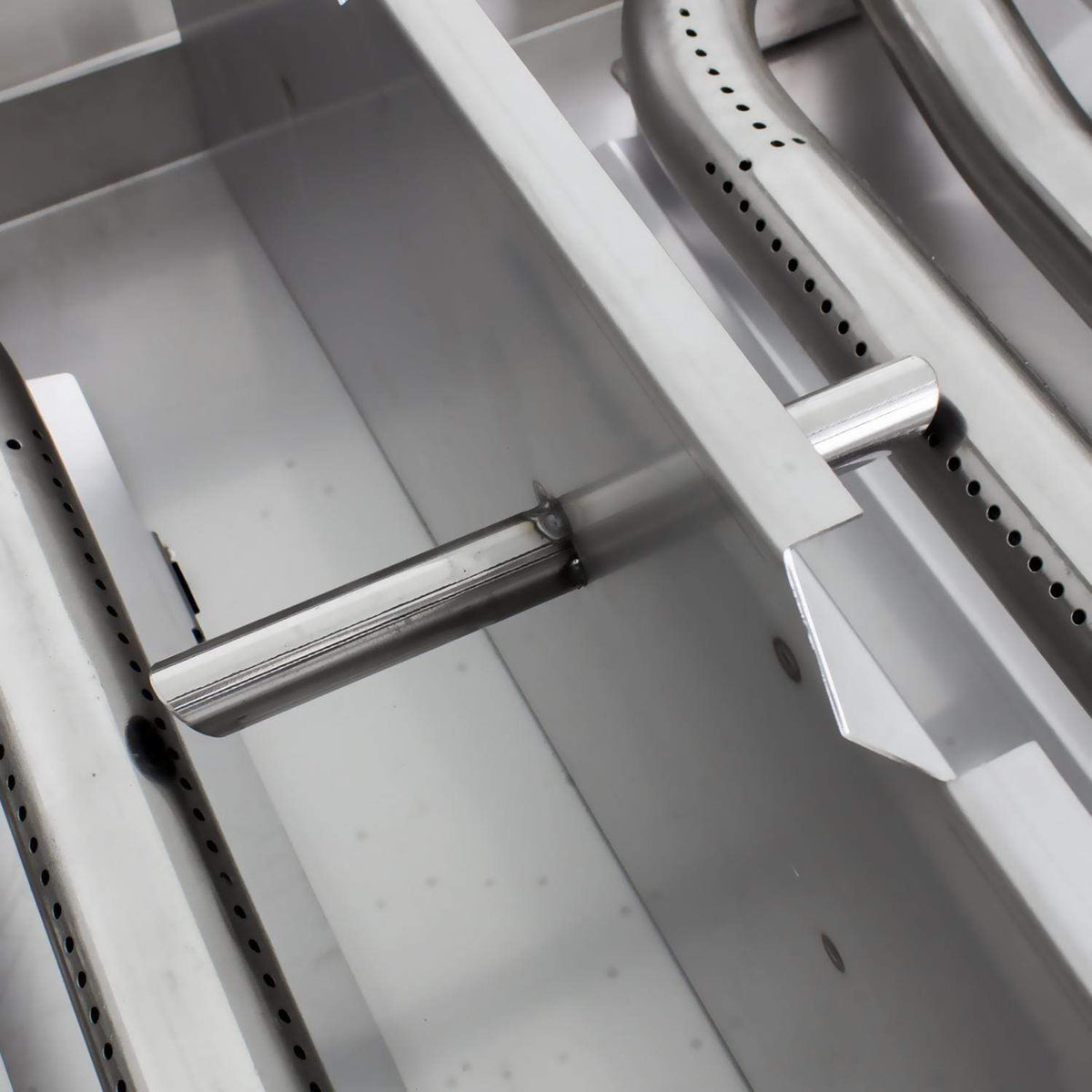 Stainless steel grill burner bars and metal heat shield inside the firebox