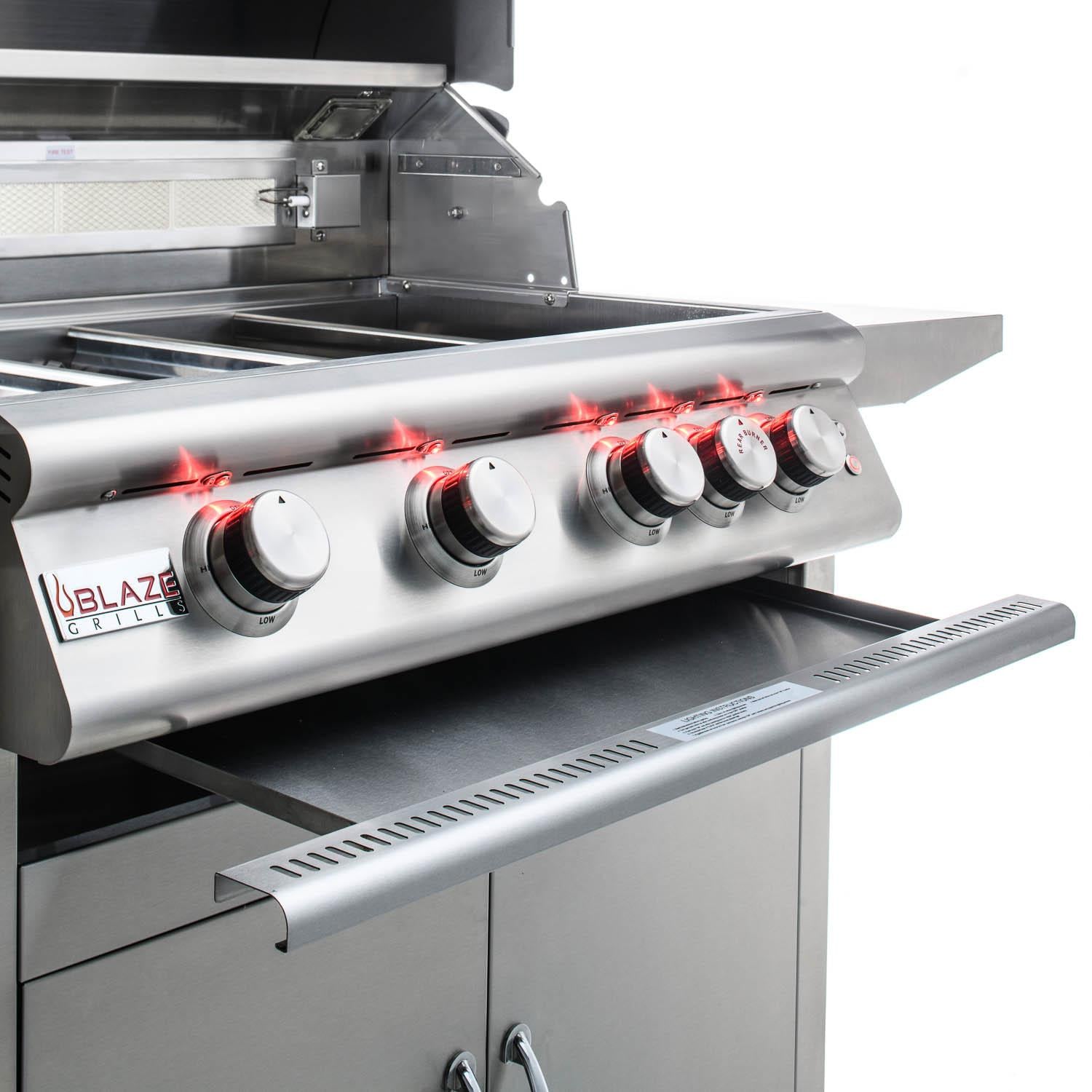 Built-in natural gas grill side view with four control knobs and open cooking area