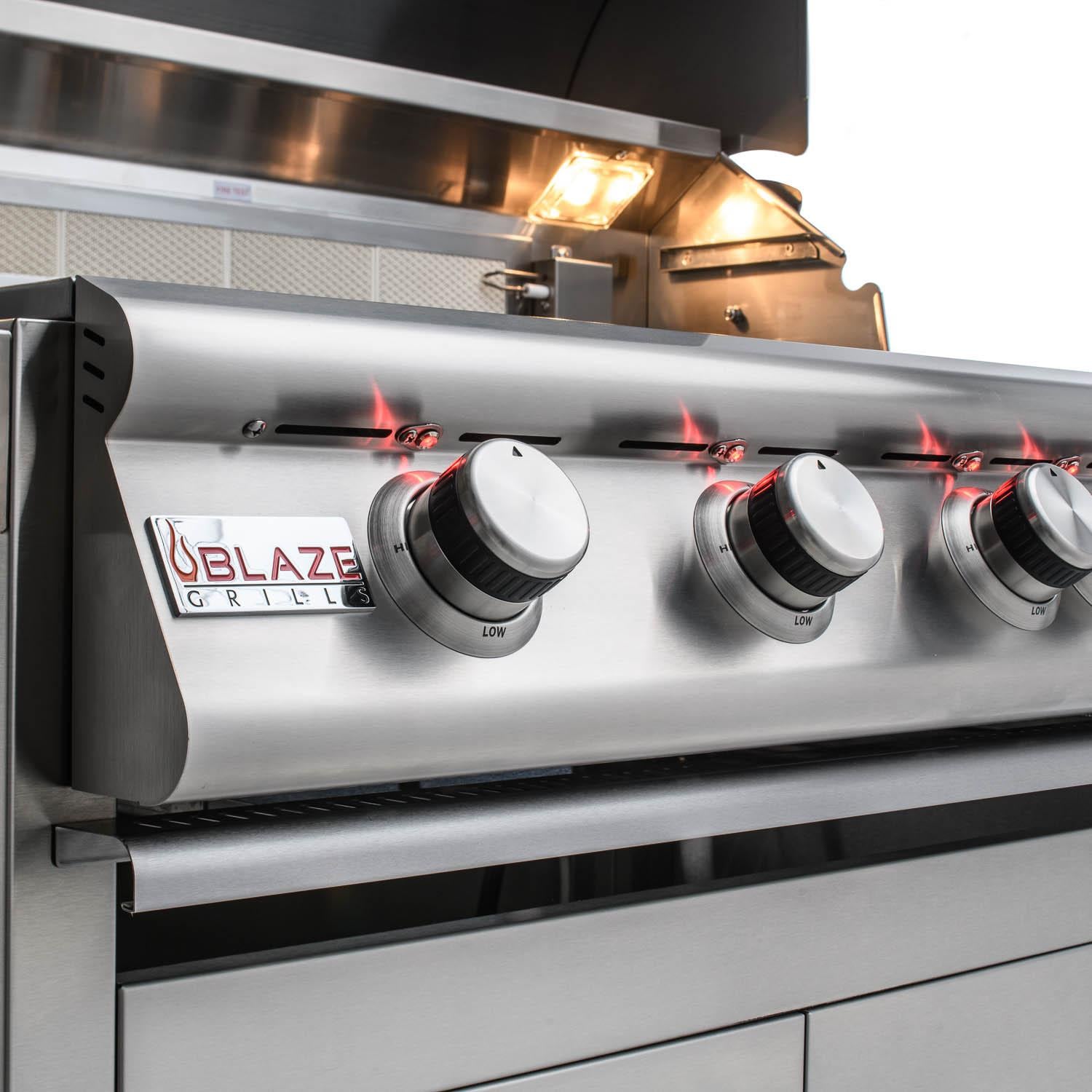 Stainless steel grill control panel with three burner knobs and flame view