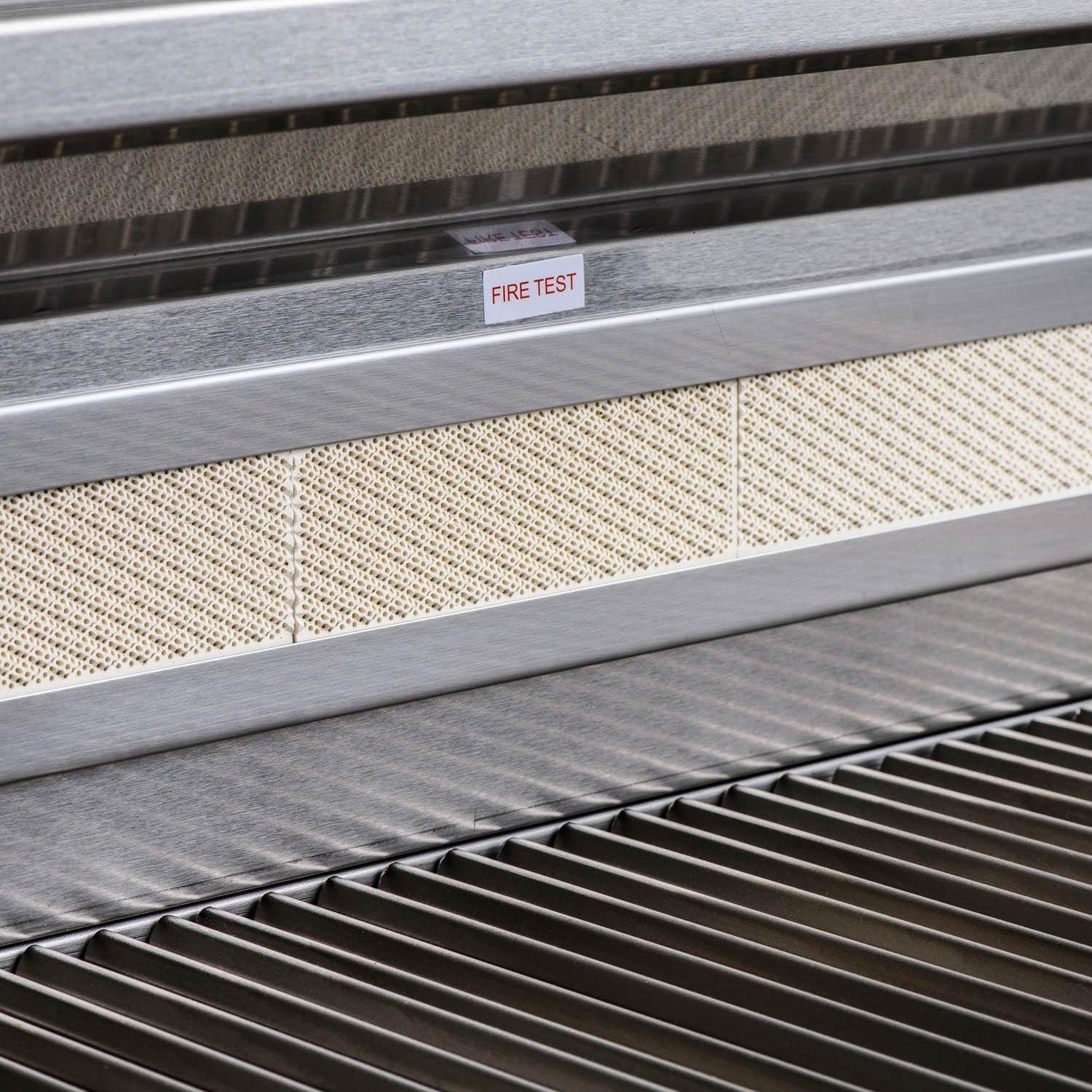 Stainless grill lower panel with 'FIRE TEST' label and front grill grates