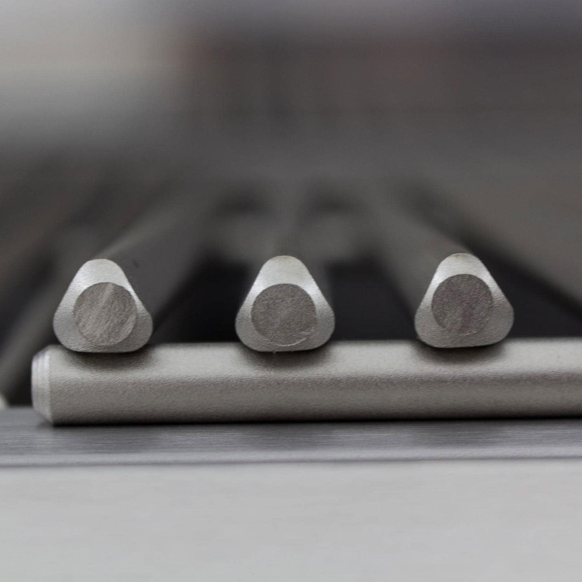 Stainless steel burner tube ends on a grill cooking area