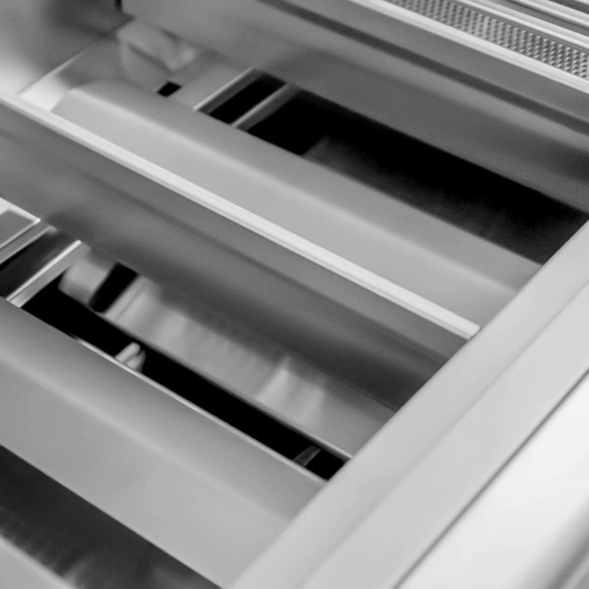 Stainless steel firebox bars and burner area interior close-up