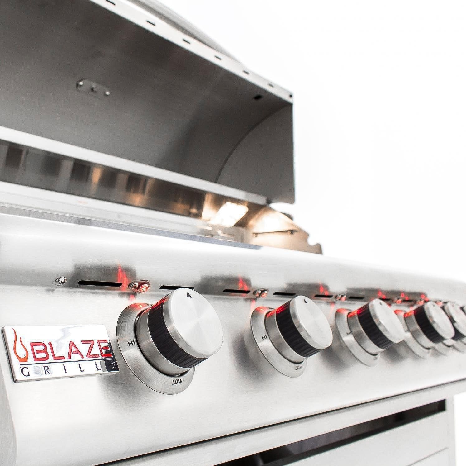 Stainless steel grill with illuminated burners and row of control knobs