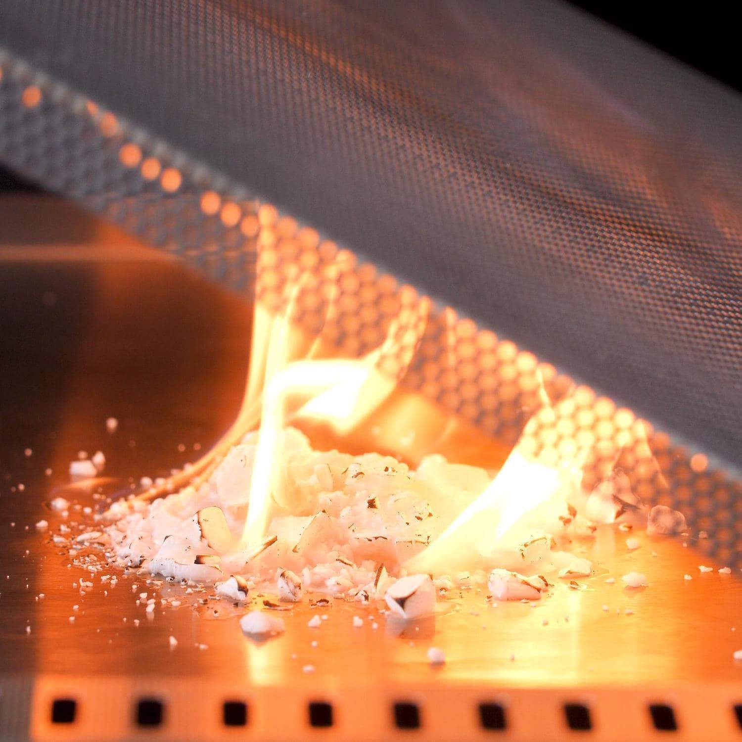 Burner flames heating the stainless steel firebox with scattered pieces