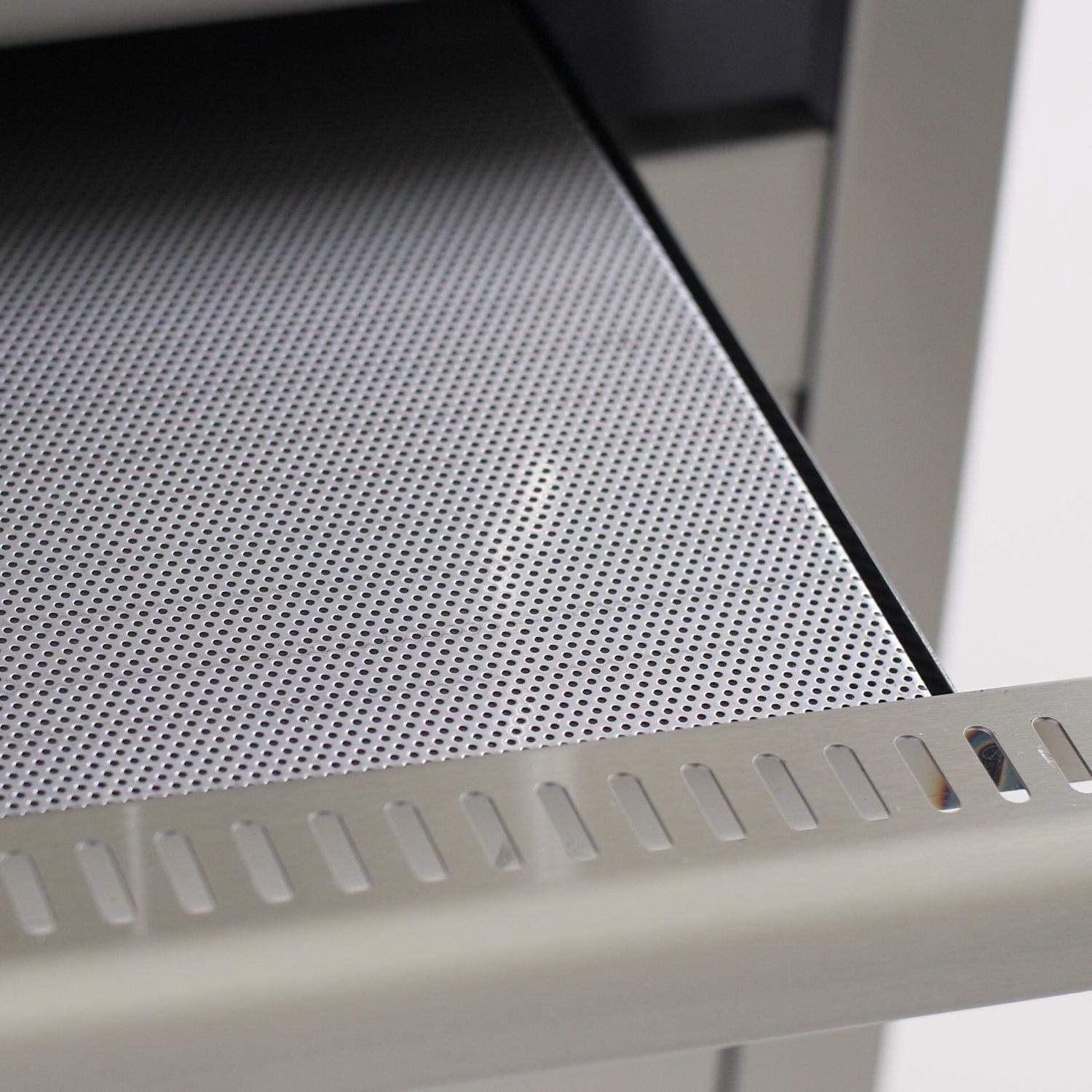 Perforated stainless steel warming tray inside the grill body