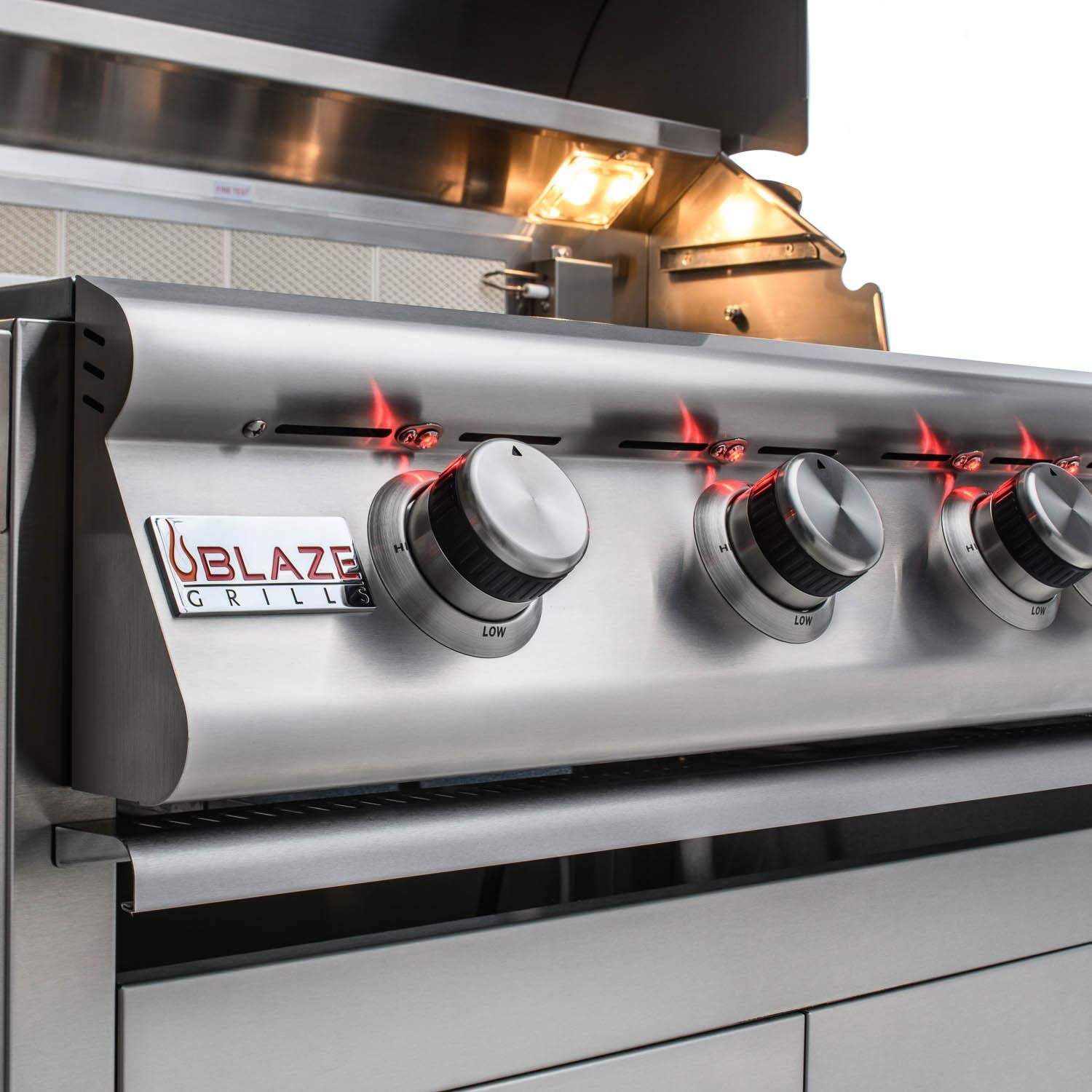 Stainless steel burner control panel with four knobs and glowing flames