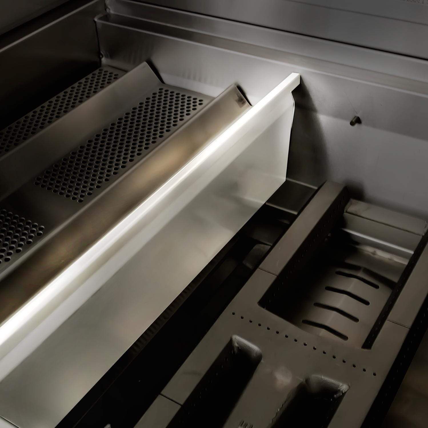 Grill interior with stainless heat shield, side burner area, and cooking grate sections