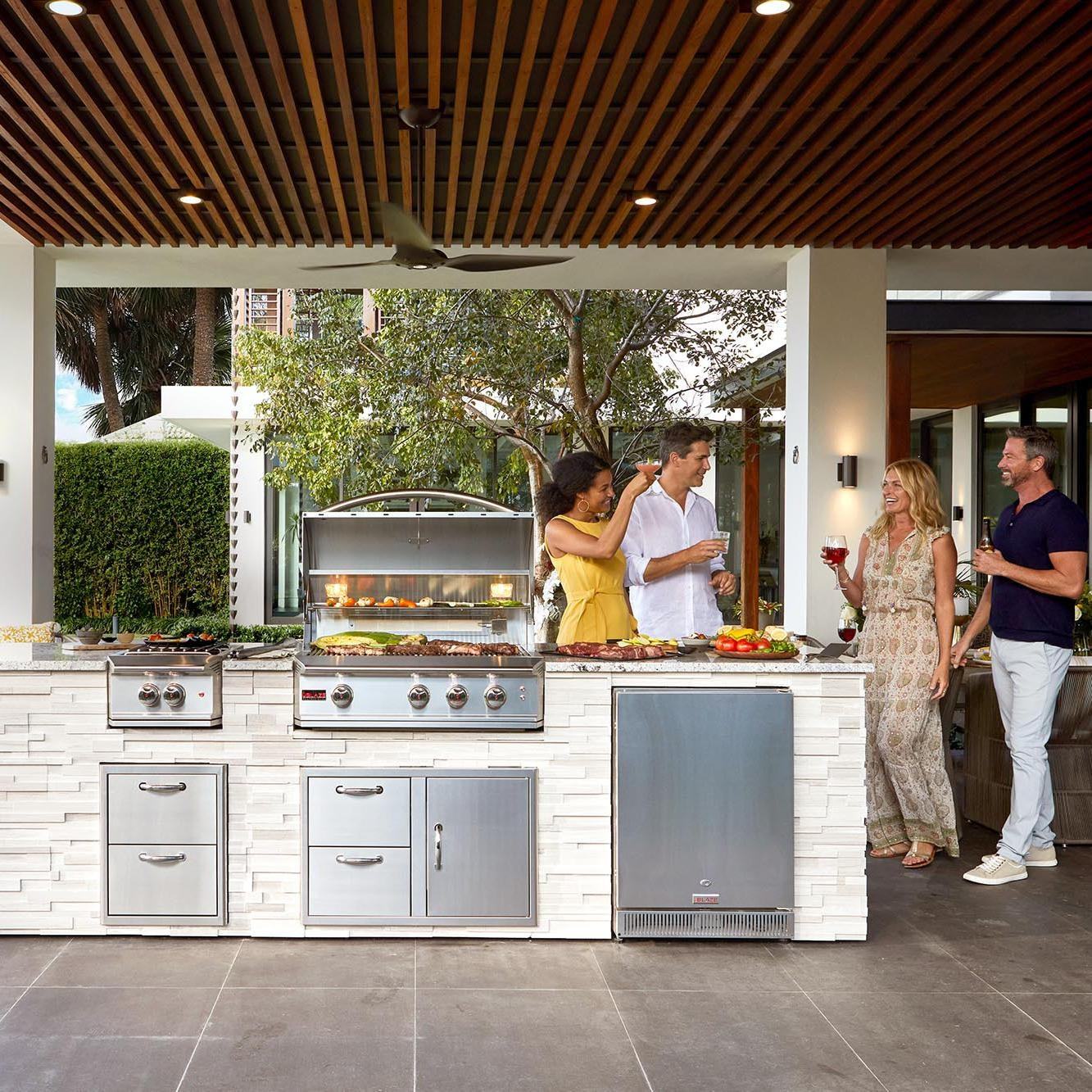 Stainless steel outdoor kitchen grill setup with side burner and warming area